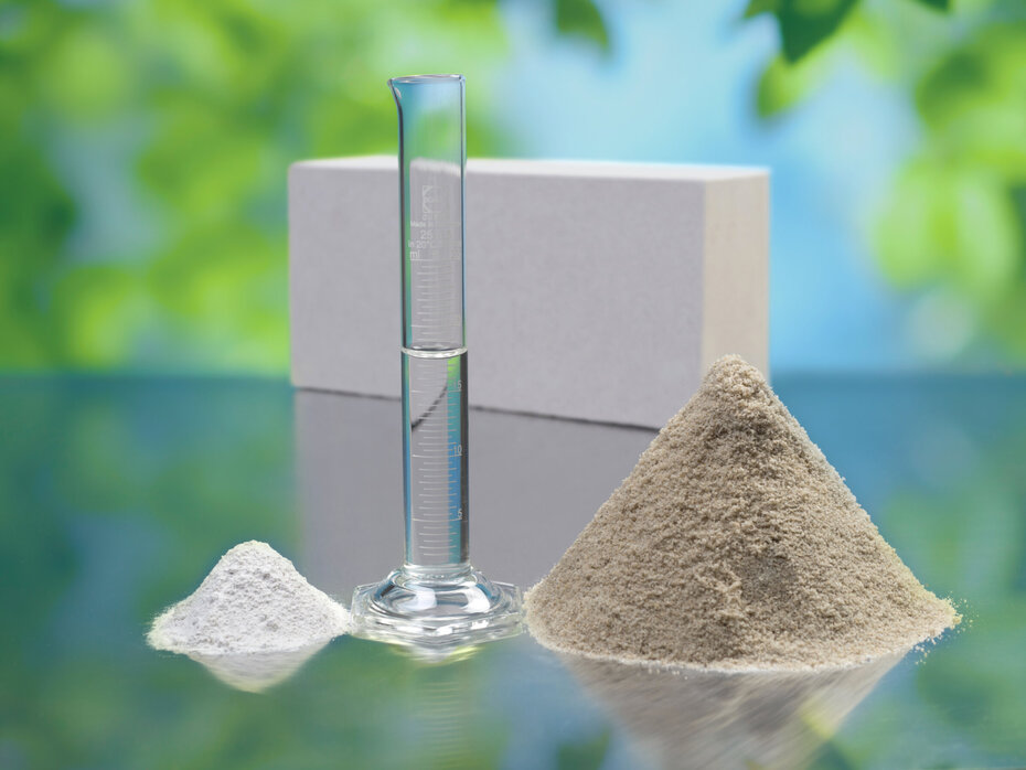 Kalk, Sand und Wasser vor einem Kalksandstein.