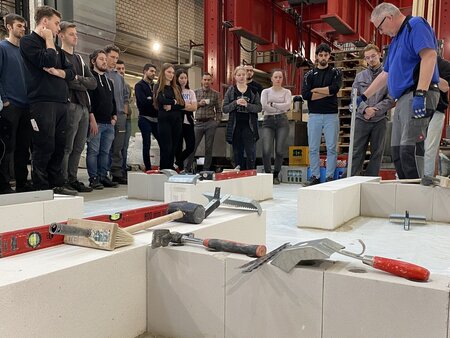 Praxisworkshop zum Bauen mit Kalksandstein mit Teilnehmenden und Fachreferent