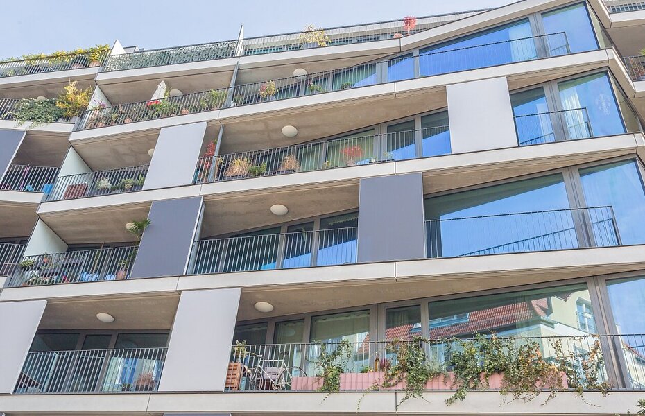 Fassade des Wohnprojekts PolygonGarden in Berlin-Friedrichshain mit Balkonen, großen Fenstern und horizontal gegliederten Geschossen