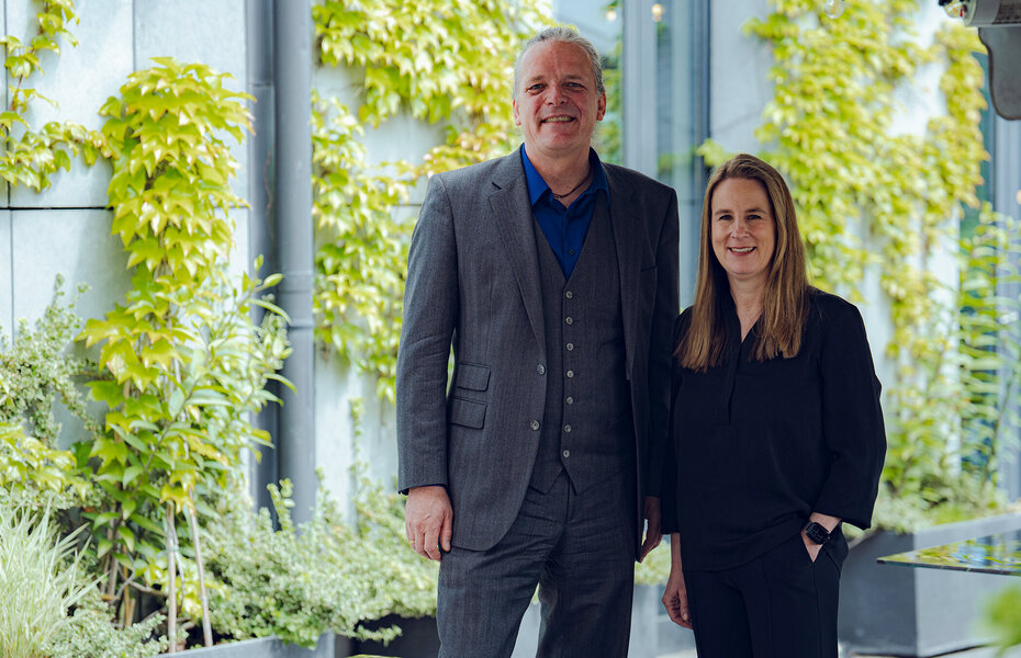 Frederic Dörlitz und Michelina von Peterffy-Rolff, neue Führung des Bundesverbands Kalksandsteinindustrie e.V., stehen gemeinsam vor einer begrünten Gebäudefassade.
