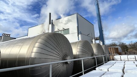 Außenansicht eines Kalksandsteinwerks mit technischen Anlagen zur Herstellung von Kalksandstein
